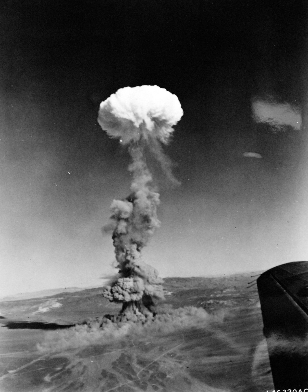 A nuclear test mushroom cloud rising over the desert