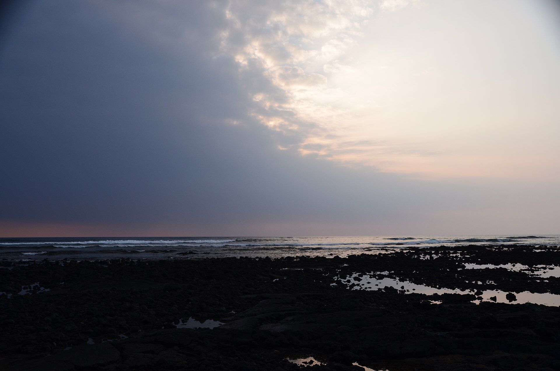 Lava shoreline at Kaloko-Honokōhau under a low evening sky