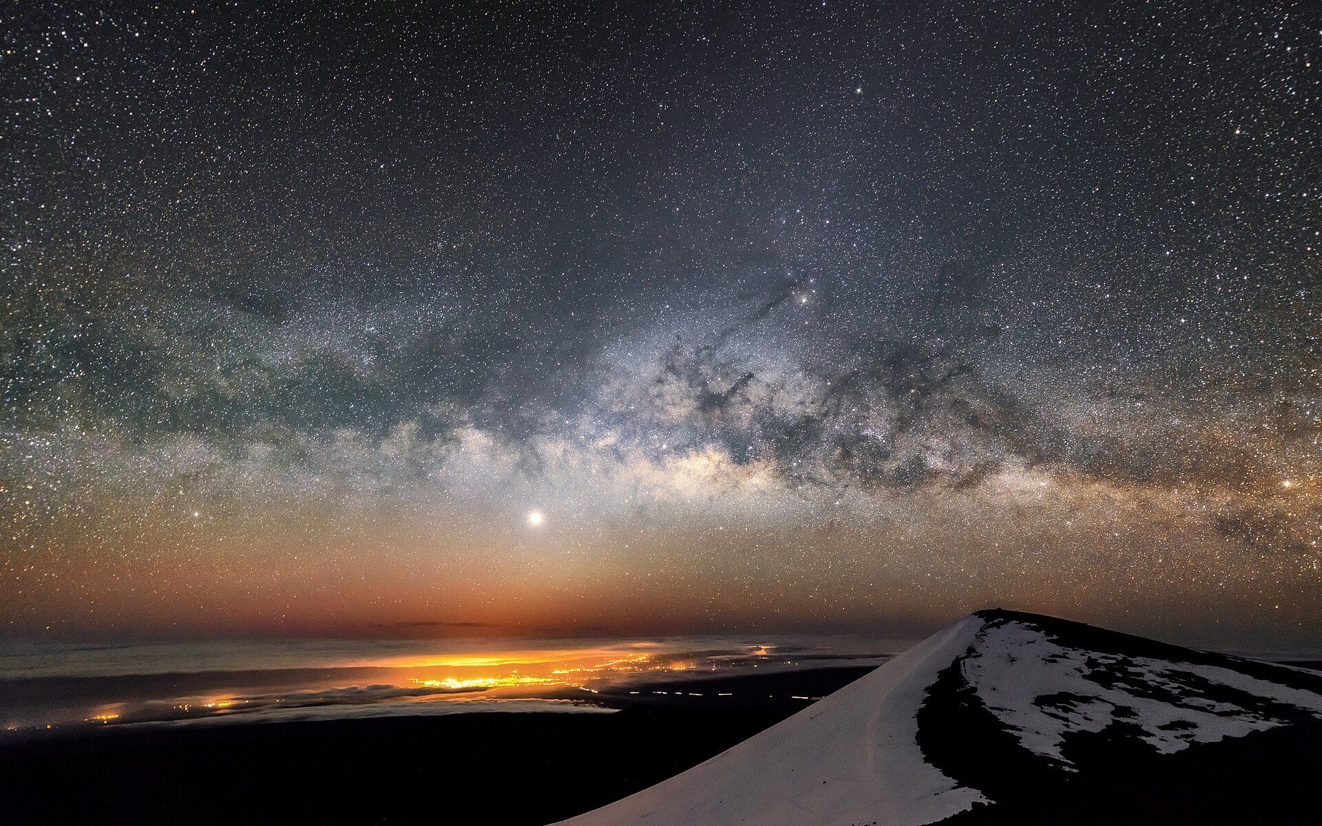 The Milky Way arching over the dark summit ridge of Mauna Kea