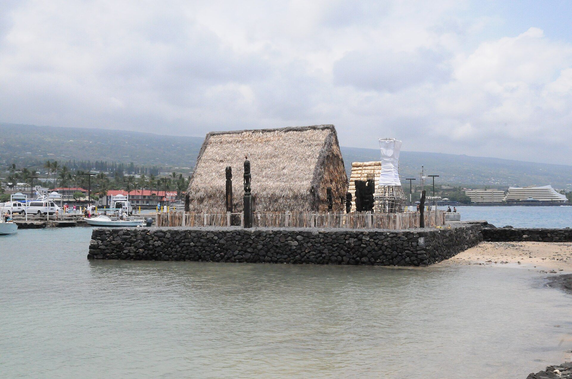 The thatched Ahuʻena Heiau on a stone platform in the water beside Kailua Pier