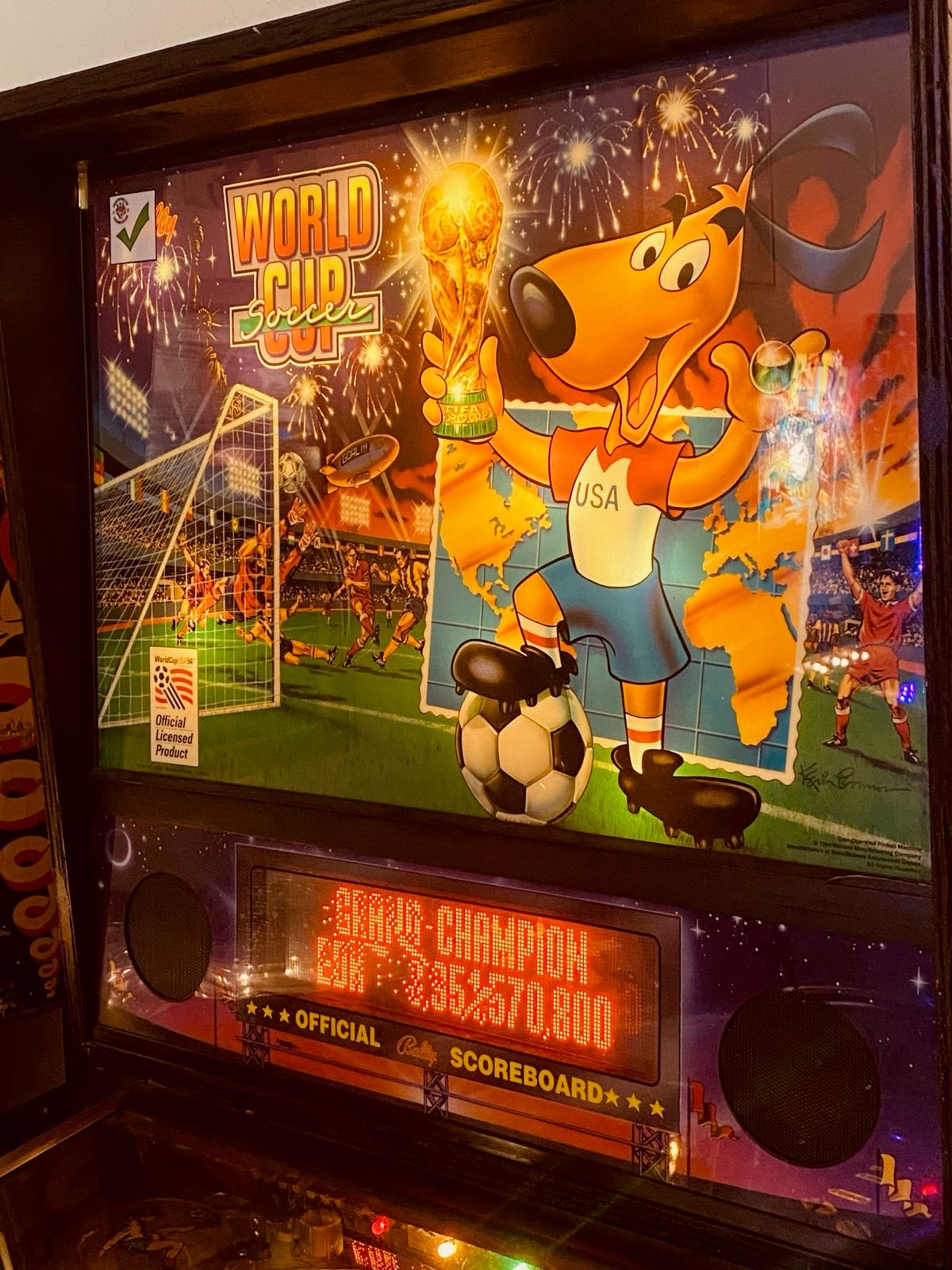 The illuminated backglass artwork of a vintage pinball machine