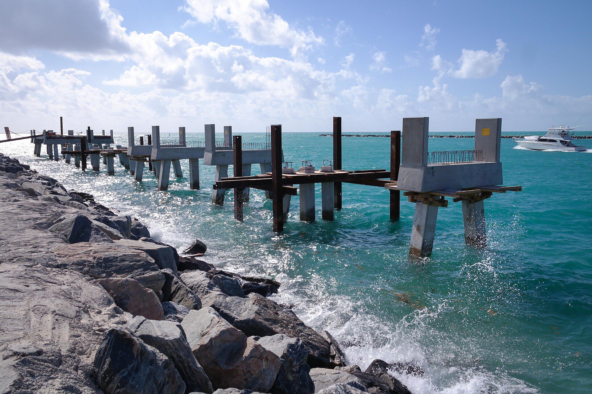 Waves breaking on the rocks beside the concrete pilings of South Pointe pier