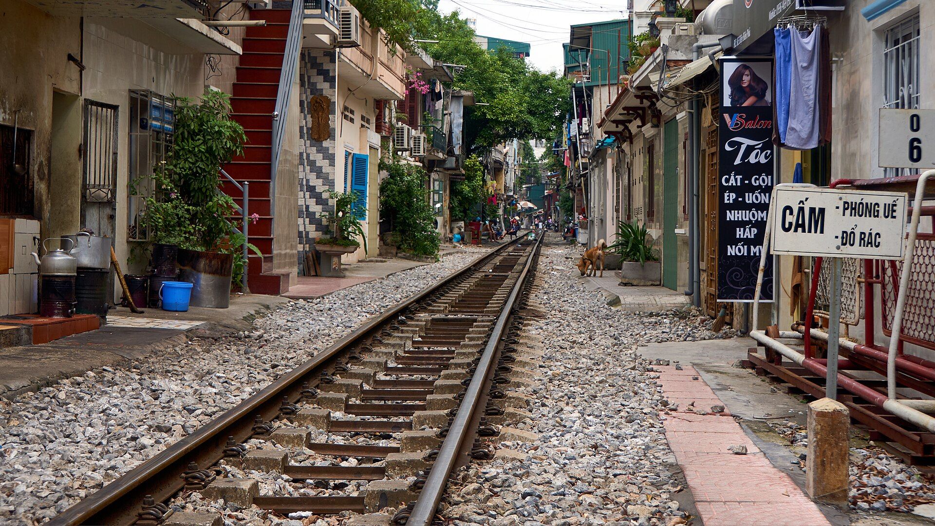 Railway tracks running between narrow houses and café fronts on Train Street