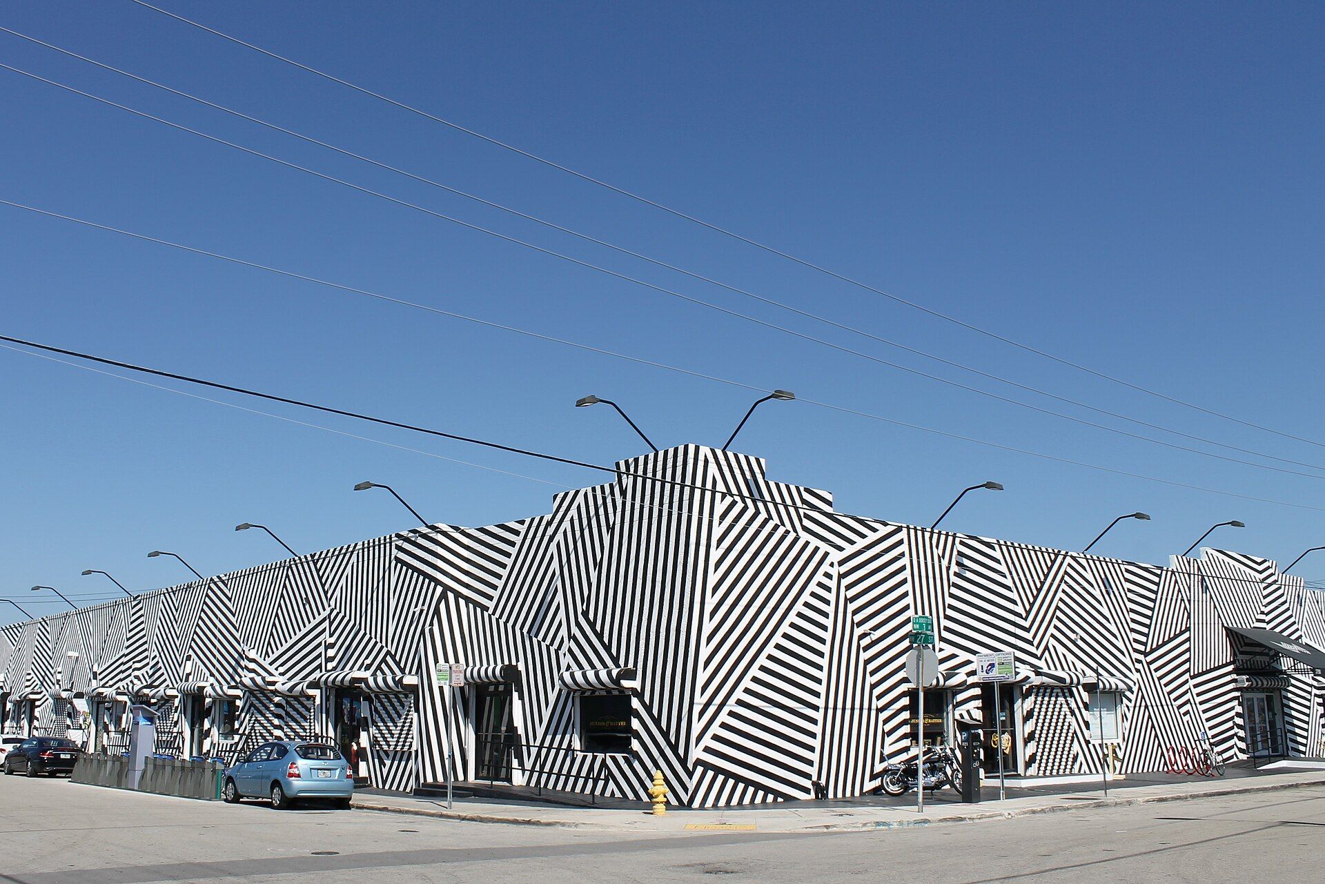 A warehouse painted in bold black and white stripes under a blue sky in Wynwood