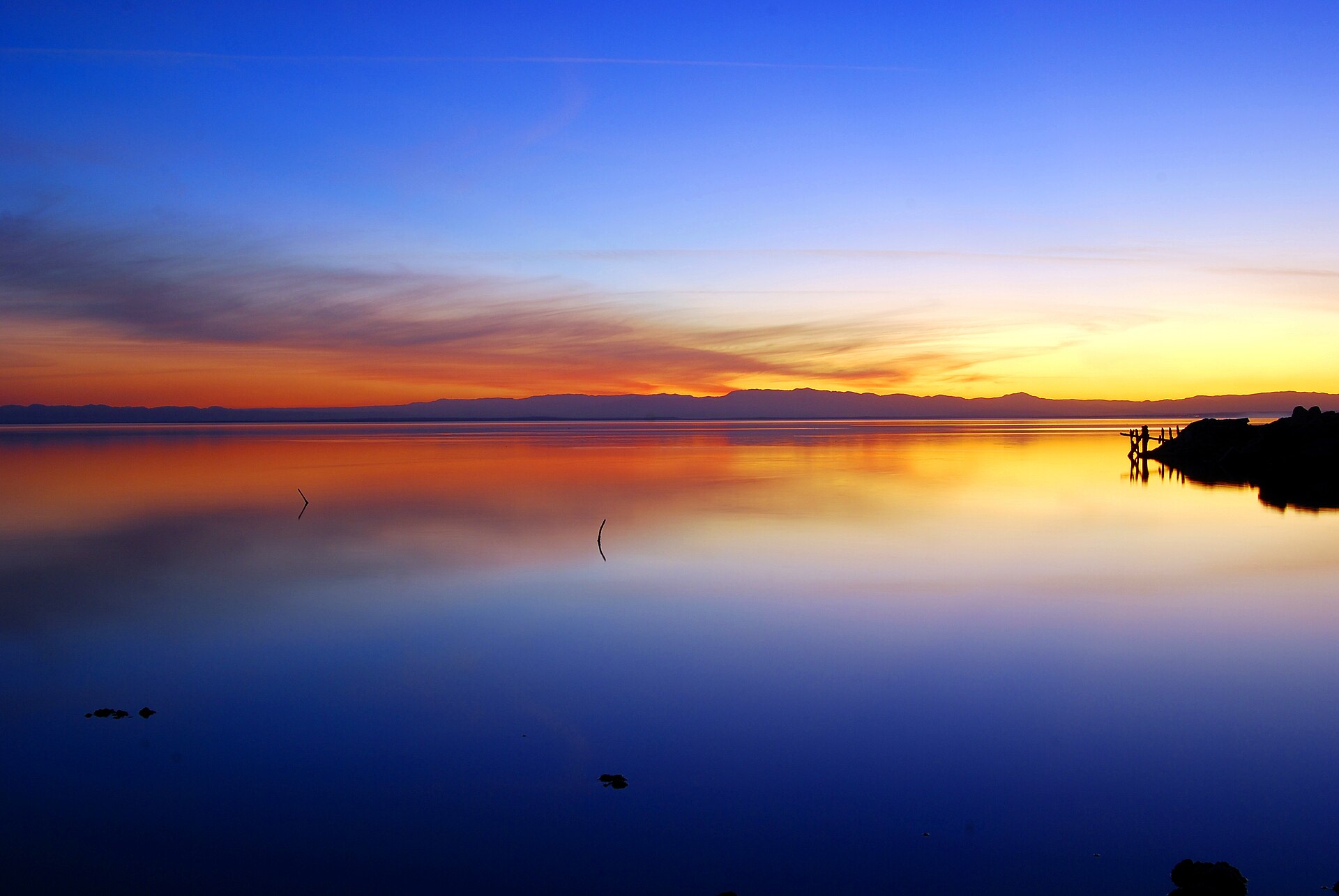 The Salton Sea at sunset, still water under an orange and grey sky