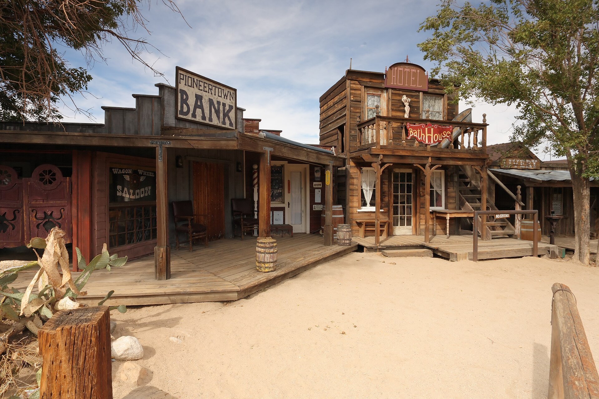 A wooden false-fronted saloon and bath house on a dirt street in Pioneertown