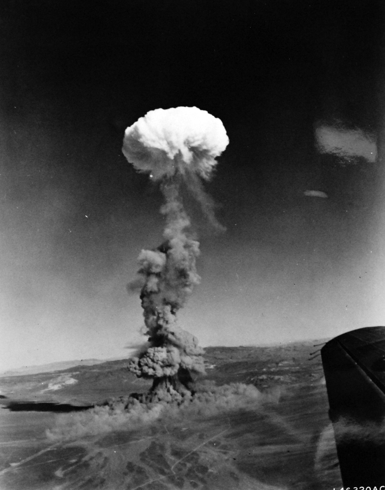 A nuclear test mushroom cloud rising over the desert