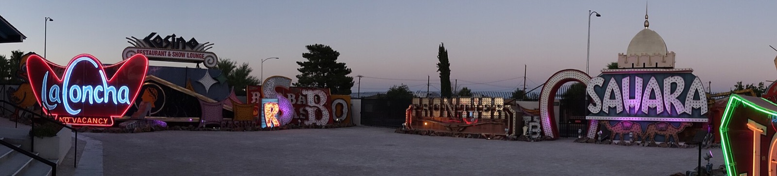 Old neon casino signs standing in the Neon Museum boneyard at dusk