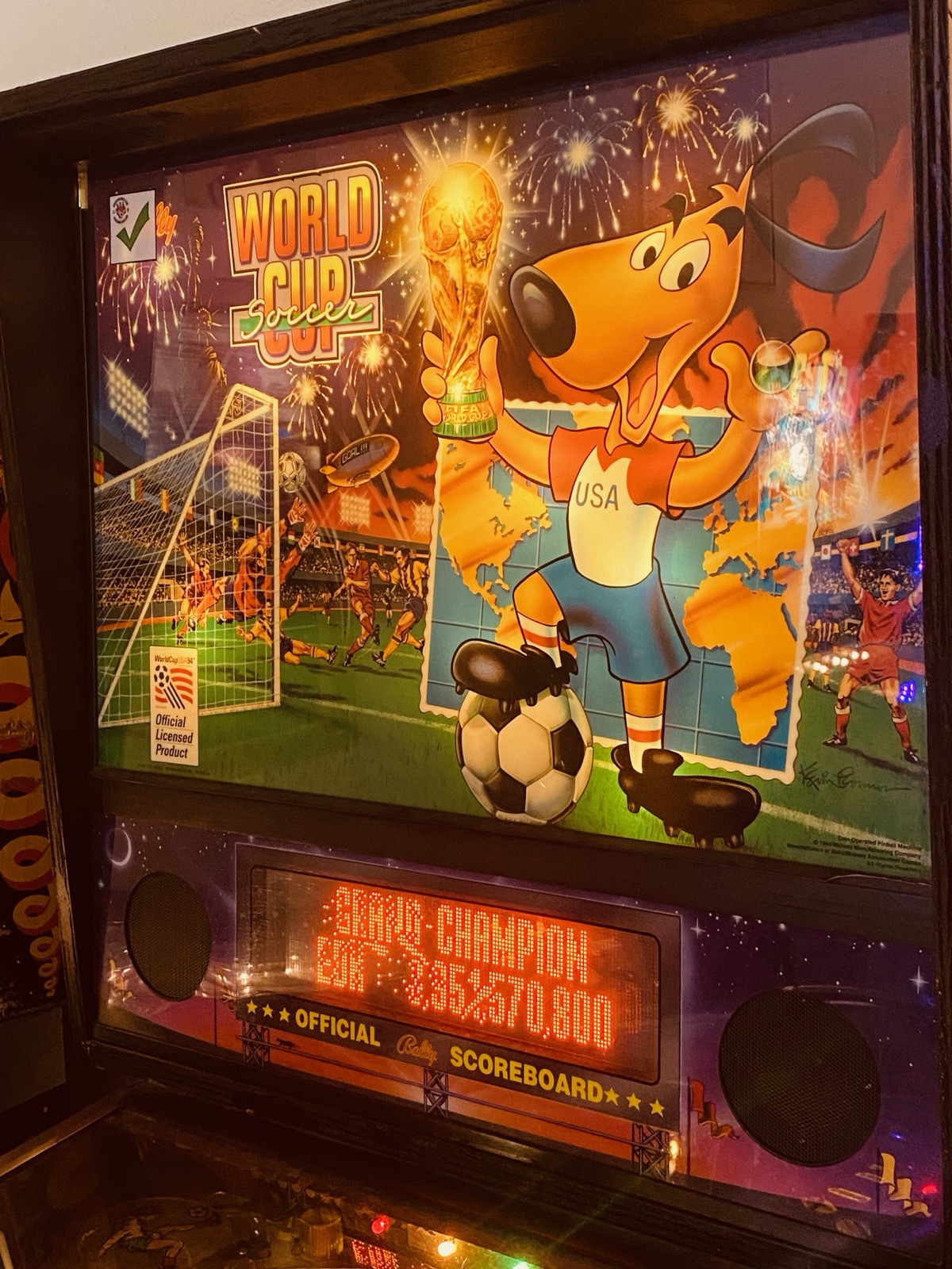 The illuminated backglass artwork of a vintage pinball machine